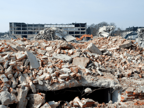 Gebouw dat gesloopt is, brokstukken liggen op de grond