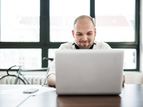 man die werkt aan laptop